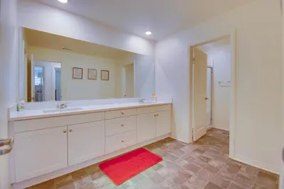a bathroom with a large white sink and a red rug at Luxurious and Spacious Family Duplex in Menifee! in Menifee