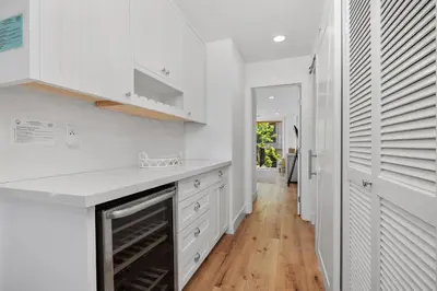 a kitchen with white cabinets and a wooden floor at Dolphin's Drift - DMST50 in Solana Beach