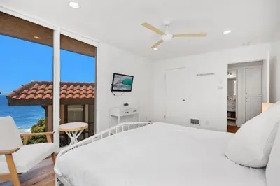 a bedroom with a white bed and a large window at Dolphin's Drift - DMST50 in Solana Beach