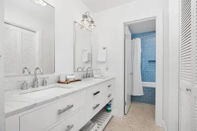 a white bathroom with a sink and a mirror at Dolphin's Drift - DMST50 in Solana Beach