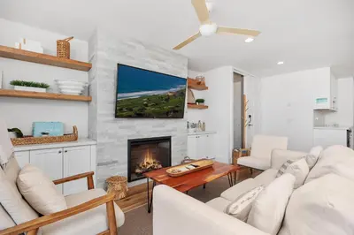 a living room with white furniture and a fireplace at Dolphin's Drift - DMST50 in Solana Beach