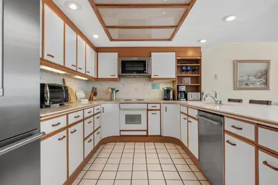 a kitchen with white cabinets and a tile floor at Ocean Infinity - DMBC727B in Solana Beach