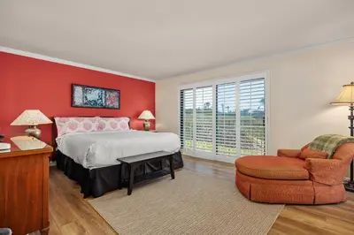 a bedroom with red walls and a bed and a chair at Sunglow Horizon - DMBC873B in Solana Beach