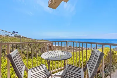 a table and chairs on a balcony with the ocean at Sunglow Horizon - DMBC873B in Solana Beach