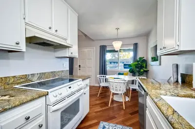 a kitchen with white cabinets and a dining room at 3080 Lincoln - Unit 12 in Carlsbad