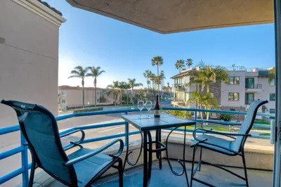 a balcony with a table and chairs and a view of a pool at 400 N Pacific - Unit 203 in Oceanside
