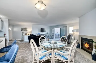 a living room with a table and chairs and a fireplace at 400 N Pacific - Unit 203 in Oceanside