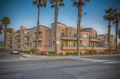 a large building with palm trees in front of a street at 400 N Pacific - Unit 203 in Oceanside
