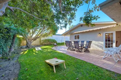 a patio with chairs and a table in the grass at 5100 El Arbol in Carlsbad