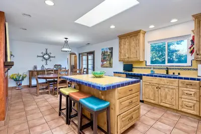 a kitchen with wooden cabinets and a table with chairs at 5100 El Arbol in Carlsbad