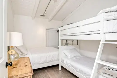 two bunk beds in a white room with a table at 3690 Carlsbad Boulevard - Unit A in Carlsbad
