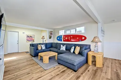 a living room with a blue couch and a surfboard on the wall at 1745 S Pacific in Oceanside