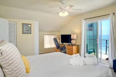 a bedroom with a bed with a ceiling fan and a television at 1745 S Pacific in Oceanside