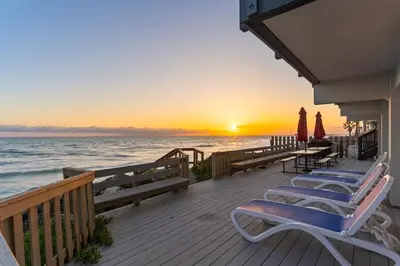 a deck with chairs and umbrellas on the beach at 1317 S Pacific - Unit C in Oceanside