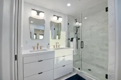 a white bathroom with two sinks and a shower at 597 S Sierra Avenue - Unit 68 in Solana Beach