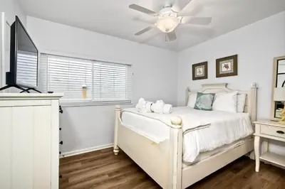 a white bedroom with a bed and a ceiling fan at 1409 S Pacific Street 5BR in Oceanside