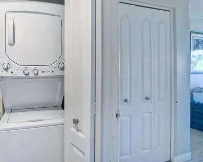 a white laundry room with a white door and a mirror at 441 S Sierra - Unit 301 in Solana Beach