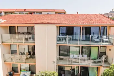 an apartment building with a balcony with chairs and tables at 441 S Sierra - Unit 301 in Solana Beach