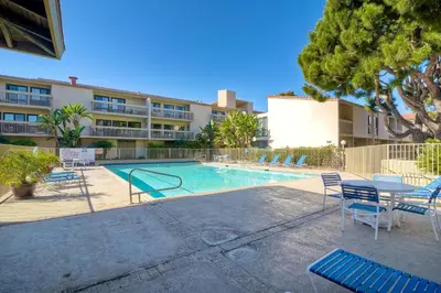 a swimming pool with chairs and a table and a building at 441 S Sierra - Unit 301 in Solana Beach