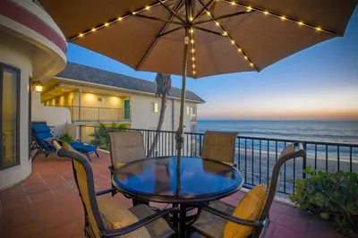 a table and chairs on a balcony with the ocean at 2751 Ocean Street in Carlsbad