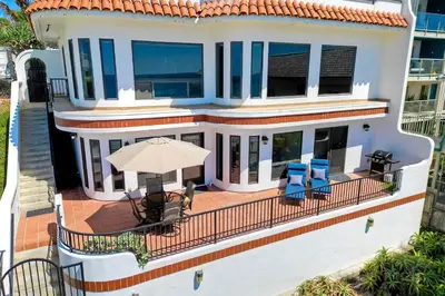 a house with a balcony with chairs and an umbrella at 2751 Ocean Street in Carlsbad