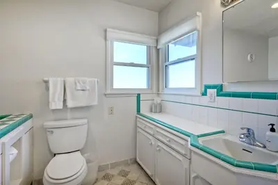 a white bathroom with a toilet and a sink at 1923 S Pacific in Oceanside