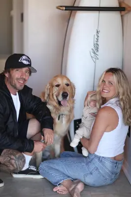 a man and a woman sitting next to a dog at West Coast Surf and Stay in San Clemente