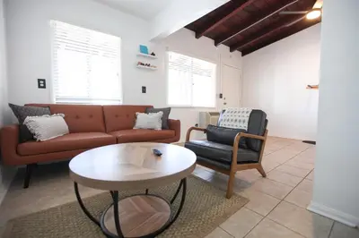 a living room with a couch and a table at West Coast Surf and Stay in San Clemente