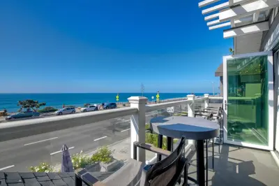 a balcony with a table and a view of the ocean at 3636 Carlsbad Blvd - Upper in Carlsbad