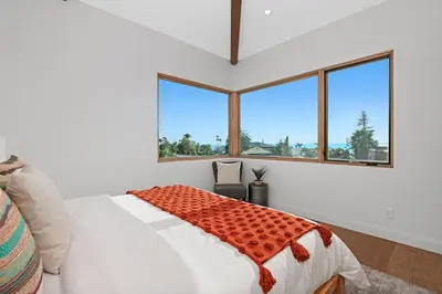 a bedroom with a bed and large windows at 5194 Carlsbad - Upper in Carlsbad