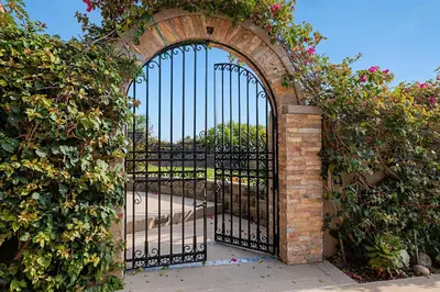 an entrance to a gate with a brick and iron fence at 5194 Carlsbad - Upper in Carlsbad
