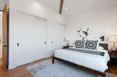 a white bedroom with a bed and a large sliding door at 5194 Carlsbad - Upper in Carlsbad