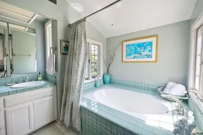a bathroom with a tub and two sinks at 5051 Shore Drive in Carlsbad
