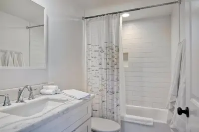 a white bathroom with a sink and a toilet at 3690 Carlsbad Boulevard - Entire Home in Carlsbad