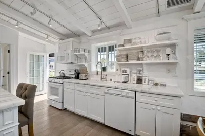 a white kitchen with white cabinets and white appliances at 3690 Carlsbad Boulevard - Entire Home in Carlsbad