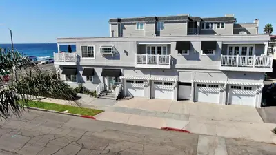 a large white house with the ocean in the background at 3690 Carlsbad Boulevard - Entire Home in Carlsbad