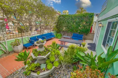 an outdoor patio with blue chairs and plants at Steps to ocean & bay large patio 4 parking spots in San Diego