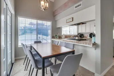 a kitchen with a table and chairs and a sink at Steps to ocean & bay large patio 4 parking spots in San Diego