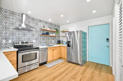 a kitchen with a stainless steel refrigerator and wooden cabinets at 2003 Costa Del Mar Road - Unit 663 in Carlsbad