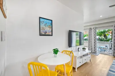 a dining room with a white table and yellow chairs at 2003 Costa Del Mar Road - Unit 663 in Carlsbad