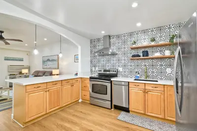 a kitchen with wooden cabinets and a stainless steel refrigerator at 2003 Costa Del Mar Road - Unit 663 in Carlsbad