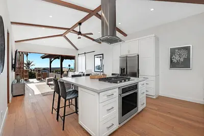 a kitchen with white cabinets and a table with chairs at 5194 Carlsbad - Entire Home in Carlsbad