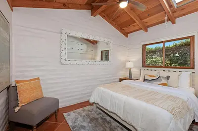 a bedroom with a bed and a chair and a mirror at 5194 Carlsbad - Entire Home in Carlsbad