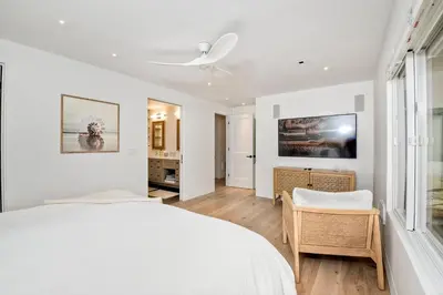 a white bedroom with a bed and a desk at 597 S Sierra Avenue - Unit 69 in Solana Beach