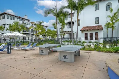 two picnic tables and lounge chairs in front of a building at 7323 Estrella Del Mar Unit 6537 in Carlsbad