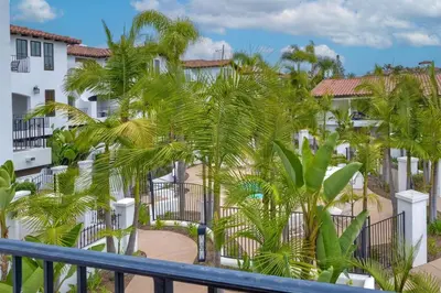 a view of a building from a balcony with palm trees at 7323 Estrella Del Mar Unit 6537 in Carlsbad