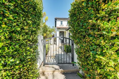 a gate in a hedge leading to a house at 9 Mi to Beach Pet-Friendly Apt in San Diego! in San Diego