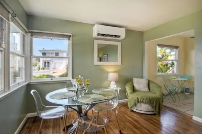 a living room with green walls and a table and chairs at 165 n 167 Tamarack in Carlsbad