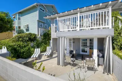 a house with a balcony and chairs on a patio at 180 n 190 Walnut Entire Home in Carlsbad