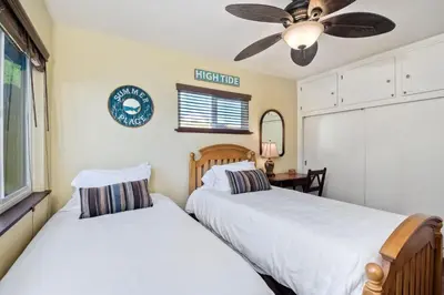 two beds in a bedroom with a ceiling fan at 5285 Shore Drive in Carlsbad
